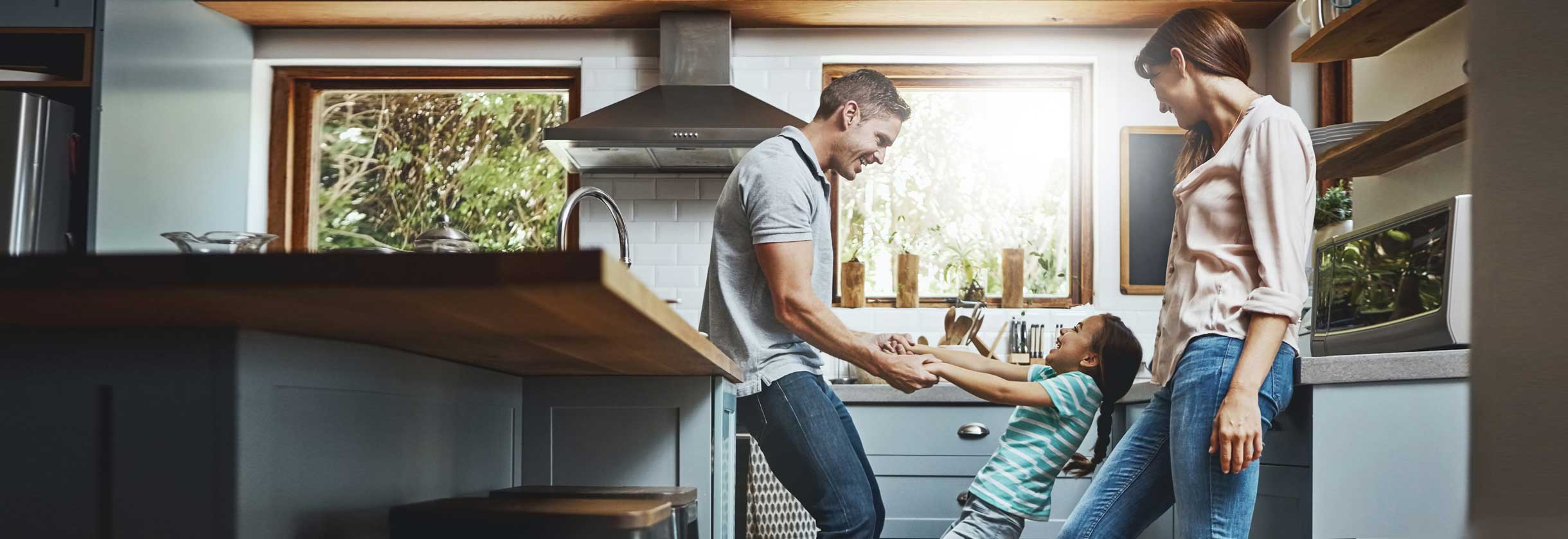 Parents playing in the kitchen with child