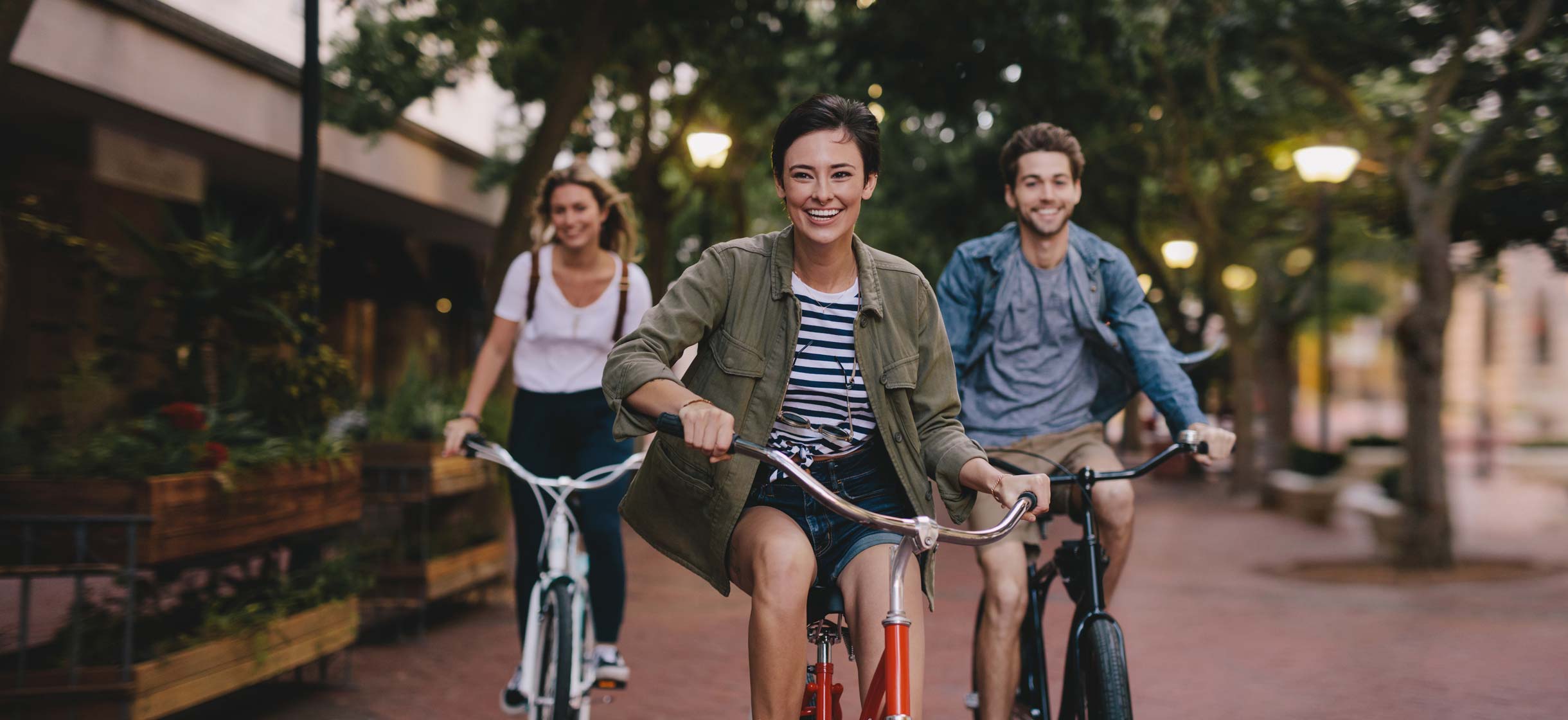 three young adults riding bicycles