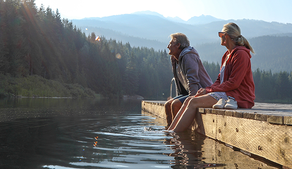 Couple sitting on the dock at a lake. 