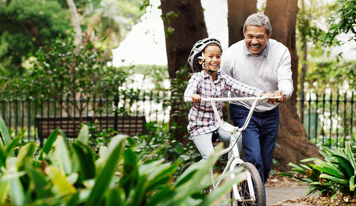 grandfather enjoying retirement with granddaughter on bicycle